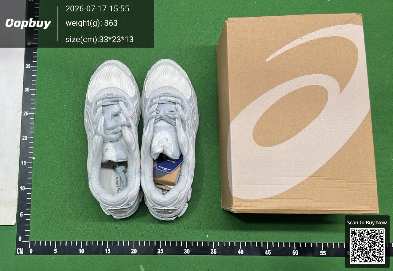 Two grey shoes beside a shoe box on a green QC measuring mat